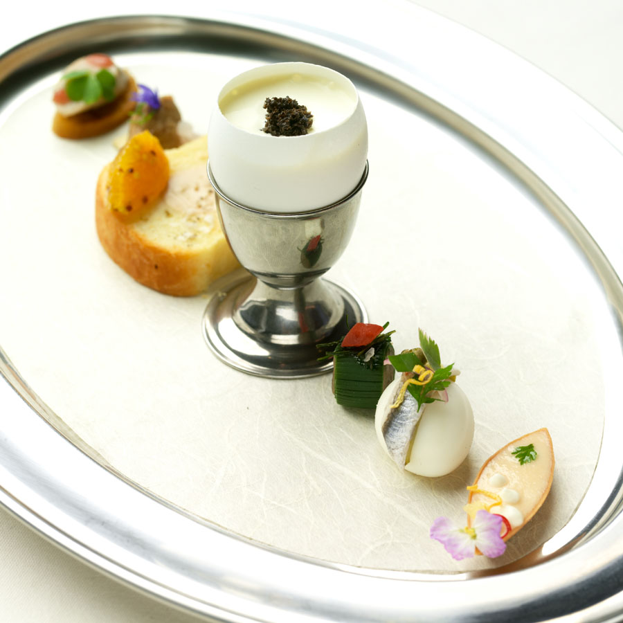 Salmon, quail egg, cracker with pork rillets, toast with foie gras filling and apricot jam, oeuf Benedictine at Next, Chicago, as part of their 2011 Paris 1906 menu.